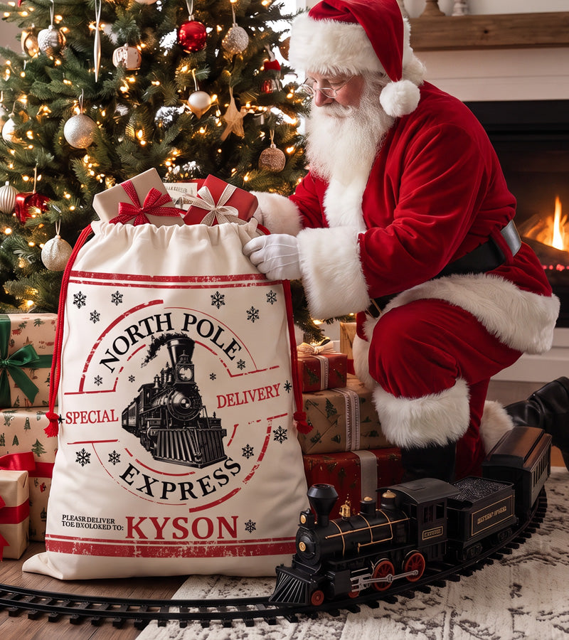 Large personalized Santa sack with a North Pole Express train design, filled with wrapped gifts beside a lit fireplace