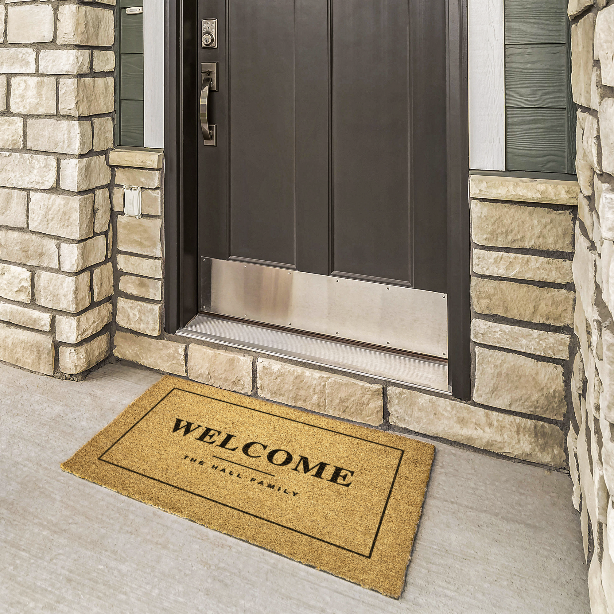 Personalized welcome mat with family name at a bronze door framed by cream stone