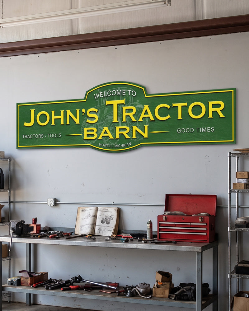 Personalized pole barn welcome sign in green and yellow above a shop bench and red toolbox
