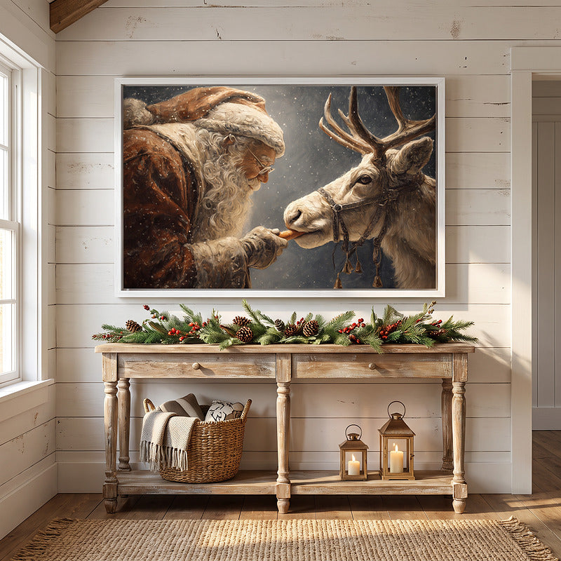 Santa and reindeer canvas in a white frame on white shiplap above a washed wood console with pine garland and lanterns