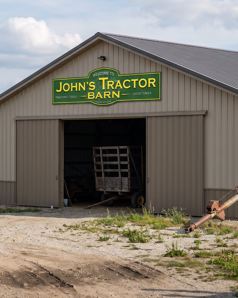 Green and yellow tractor shed sign on a tan pole barn gable above an open equipment door
