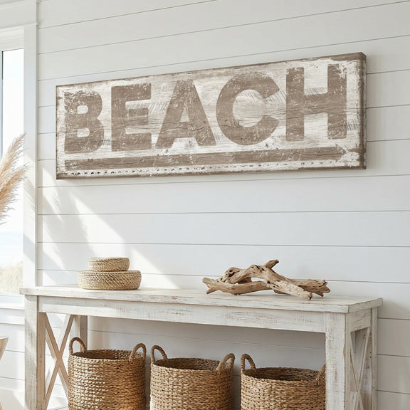 Unique coastal decor Wooden 'BEACH' sign above a white console table with wicker baskets and driftwood.