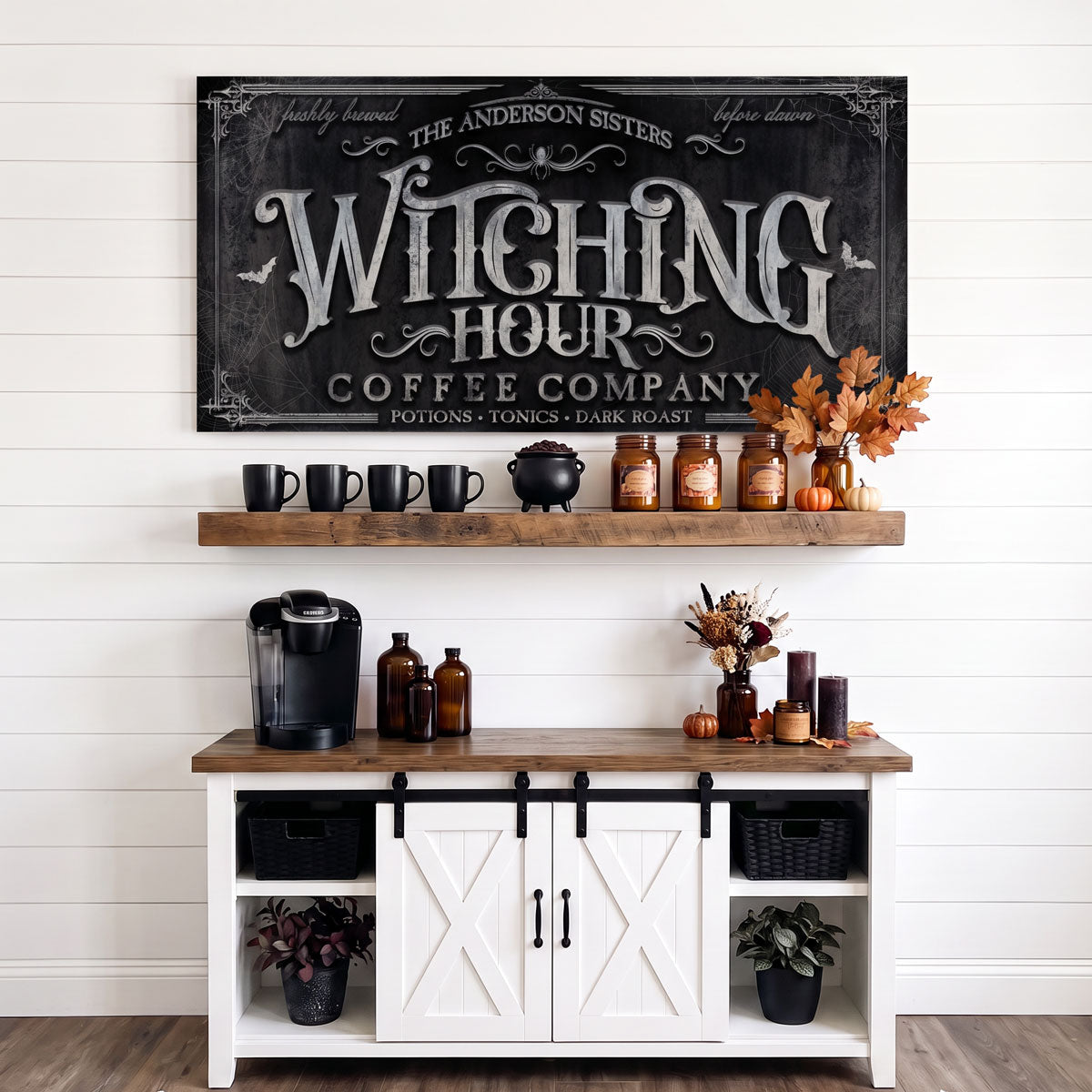 Witch coffee bar sign in black and silver above a coffee station shelf with mugs, bottles and a coffee maker