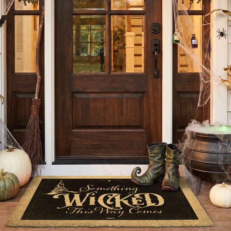 Witch doormat reading Something Wicked at a wood door with cobwebs, a broom and witch boots