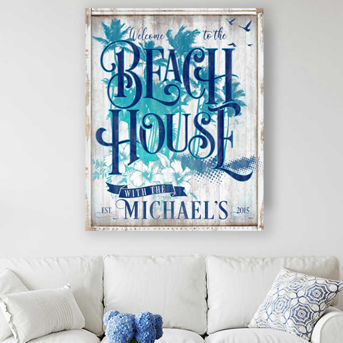 Beach house sign with palm tress in background and birds flying, with the words Beach House with the [family name] and est. date.