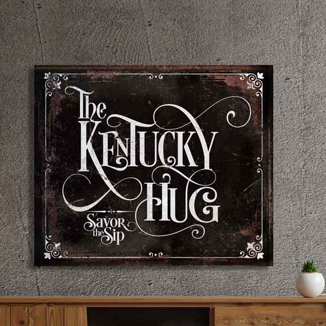Bourbon Bar Wall Sign on Black distressed, rusted faux metal, with the words [the Kentucky Hug] Savor the Sip, with white detail around edges.