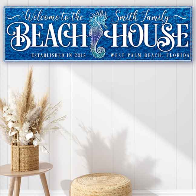 Beach house sign in deep blue, with seahorse and the words Welcome to the (family name) Beach House, with est. date and city