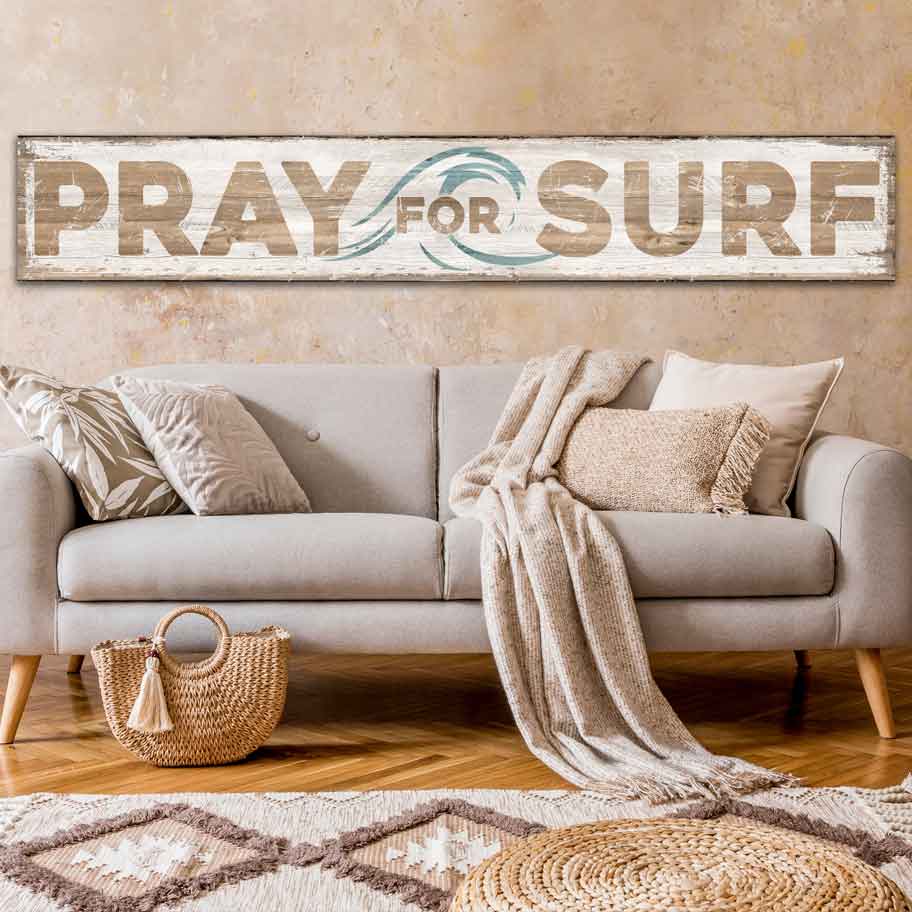 coastal decor that Reads [Pray for Surf] on canvas or metal with a white distressed wood look. blue wave on background.