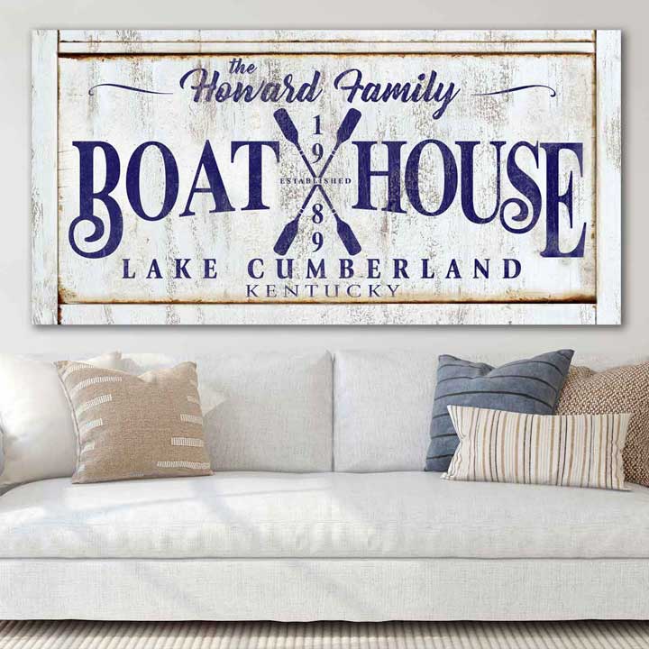 Boat house sign on rustic tan canvas, with the words personalized [family name, Boat house, date, lake name, and state] with blue lettering