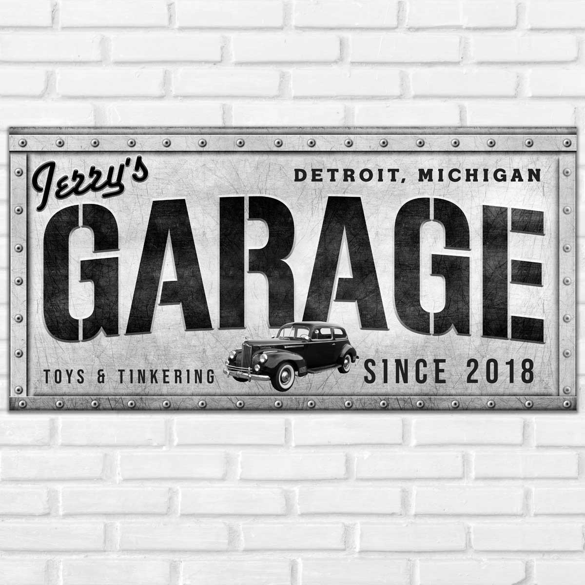 garage sign or Man cave sign is made of metal with rivets and the words, Jerry garage, city and state, toys and tinkering, with est. date.